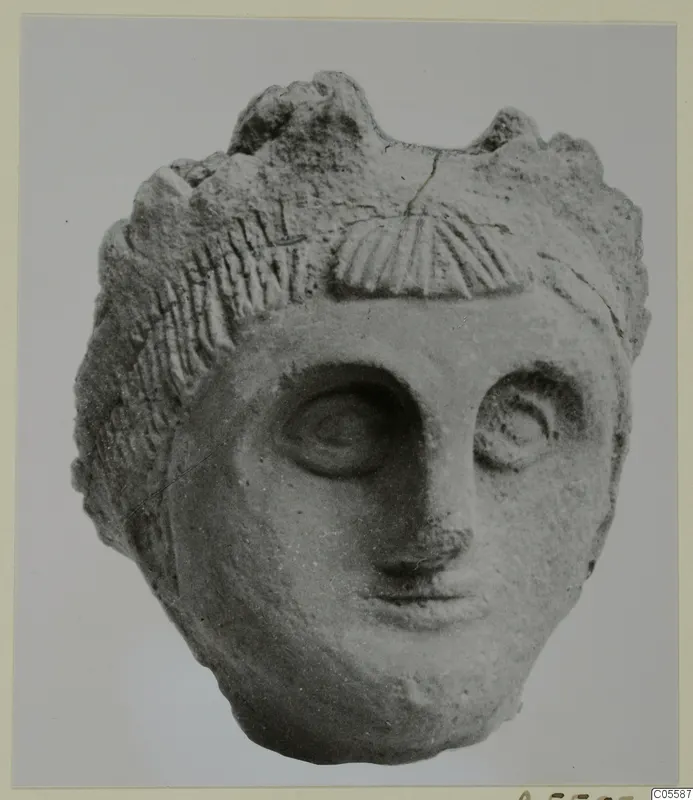 Terracotta head from Mersinaki, front view, with carved hair and a fan-shaped ridged ornament above the brow