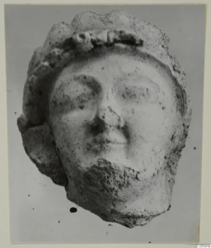 Terracotta head from Mersinaki with a rounded face and a thick band across the top of the head