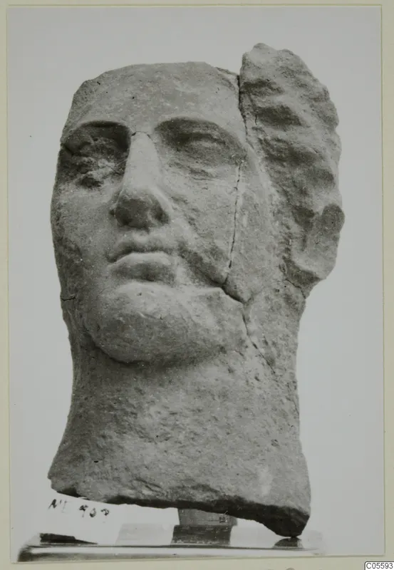 Stone head from Mersinaki, shown front-on, with the top and right side of the hair broken away.