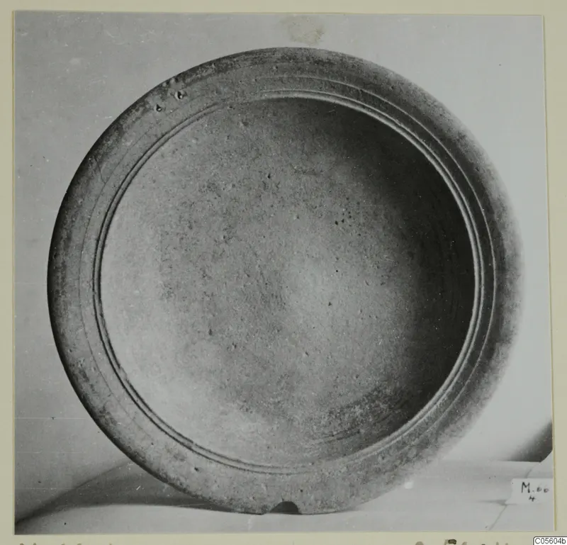 Pottery bowl seen from above, with two concentric grooves on its wide rim and a small number label at lower right