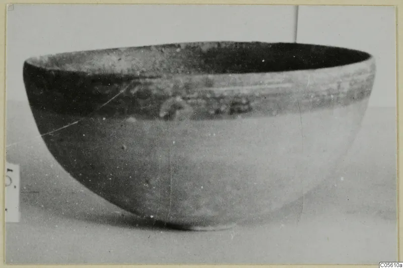 Pottery Black-on-Red II-IV bowl, deep and rounded, shown in side view against a pale background.