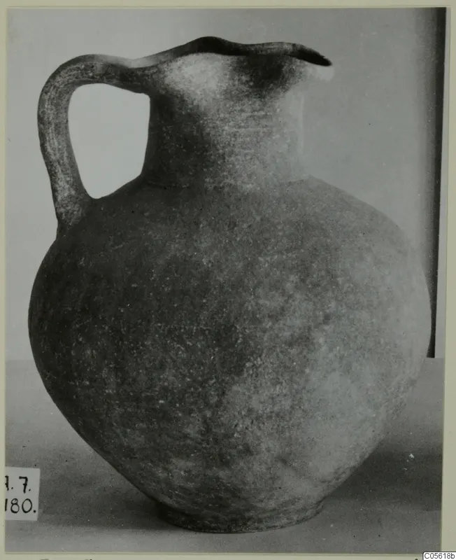 Jug with a single handle and wide trefoil-like mouth, dark surface, photographed on a plain background, from Amathus