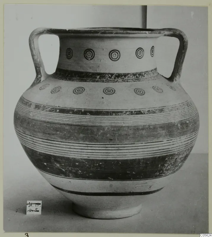 Two-handled pottery jar with concentric circles and horizontal bands, photographed against a plain background.