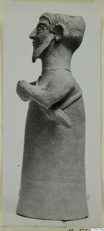 Terracotta figurine of a bearded figure with arms folded across the body, shown in profile.