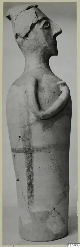 Terracotta figurine of a standing figure with one arm bent across the chest and dark painted bands on the body
