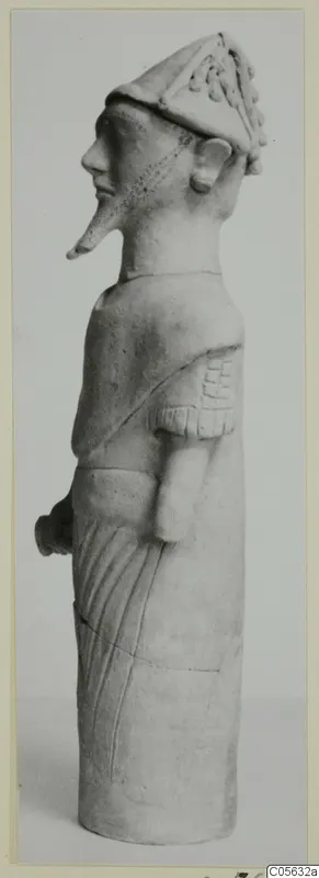 Terracotta figure in side view, with a tall peaked headdress and a long pointed nose