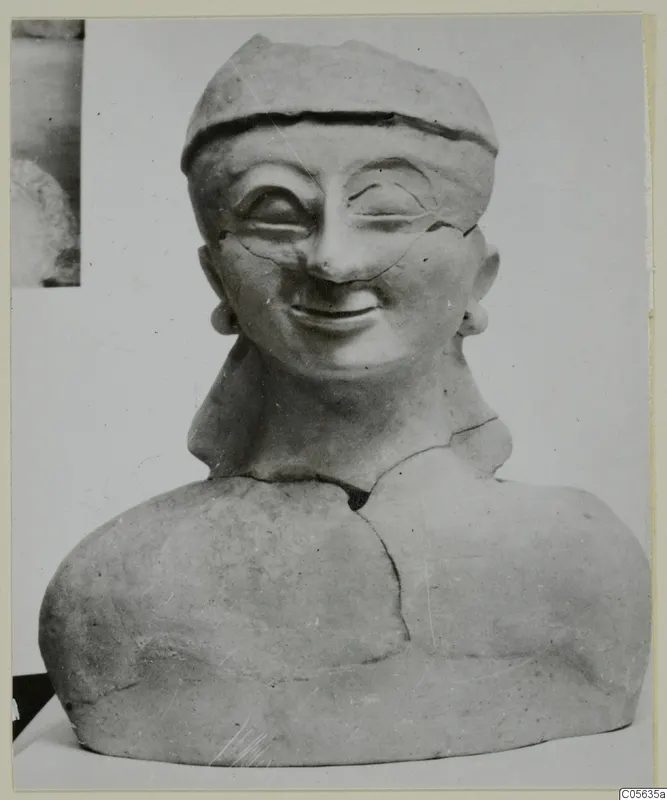 Terracotta bust of a smiling figure wearing a cap-like head covering and earrings, from Ayia Irini