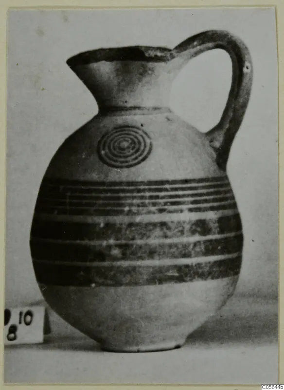 Pottery Black-on-Red II-IV jug with a concentric circle motif on the shoulder and horizontal bands around the body
