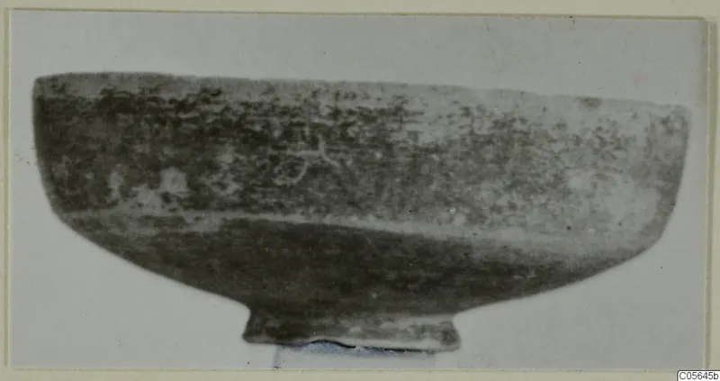 Black Slip bowl with a low foot ring, shown in side view against a pale background