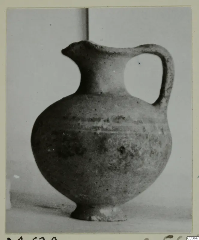 Pottery jug with a trefoil-style spout, a single loop handle and a rounded body, photographed against a plain backdrop.