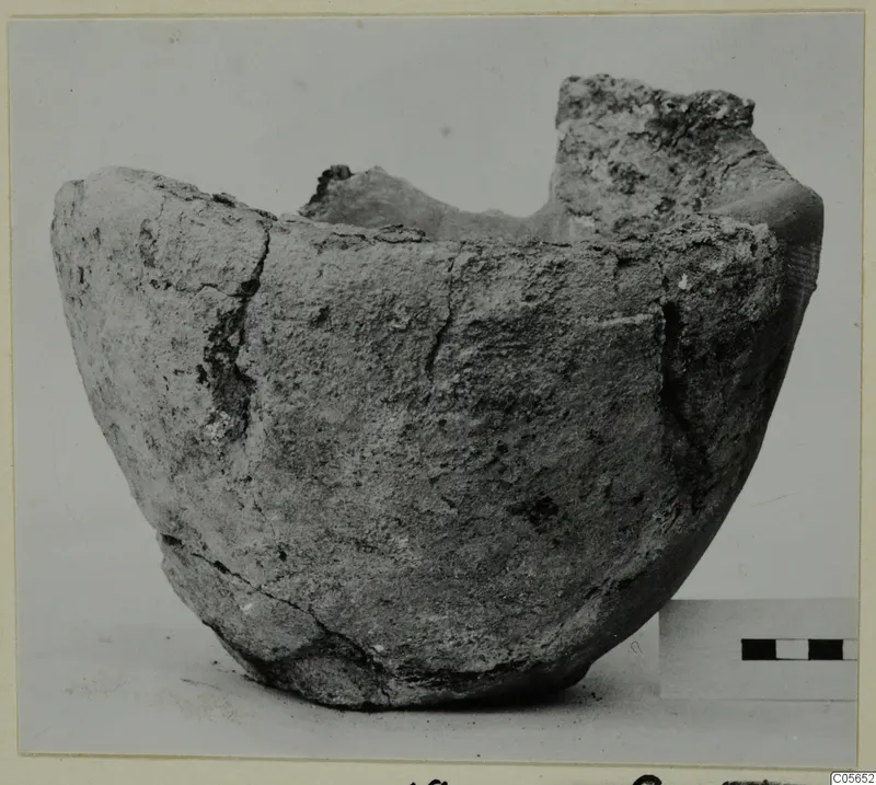 Broken pottery vessel from Marion with an uneven rim, shown beside a scale bar
