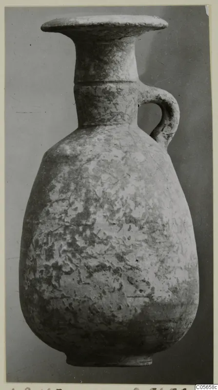 Pottery juglet from Amathus with a flared rim and single loop handle, shown against a grey background