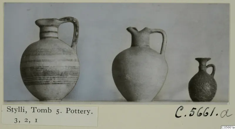 Three pottery jugs of decreasing size standing in a row, from Stylli, Tomb 5