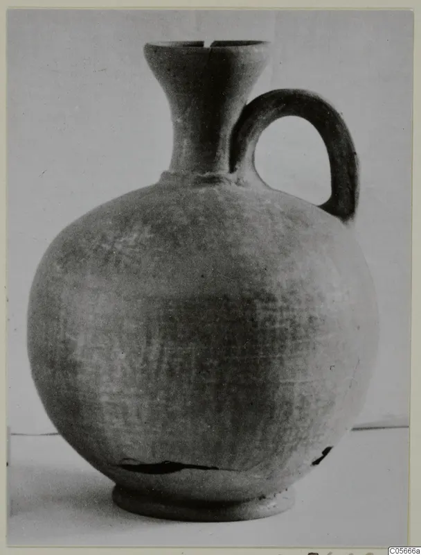 Jug in Pottery Stroke Polished Ware with a globular body, flaring neck and loop handle