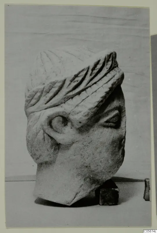 Carved limestone head from Mersinaki, broken off at the base, shown three-quarter view