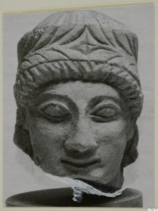 Limestone sculpture head from Mersinaki, front view, with a carved face, incised hair band and broken neck