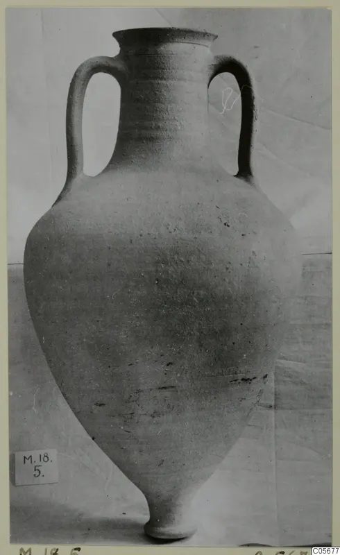 Pottery Plain White VI amphora from Marion with two handles, photographed against a draped cloth