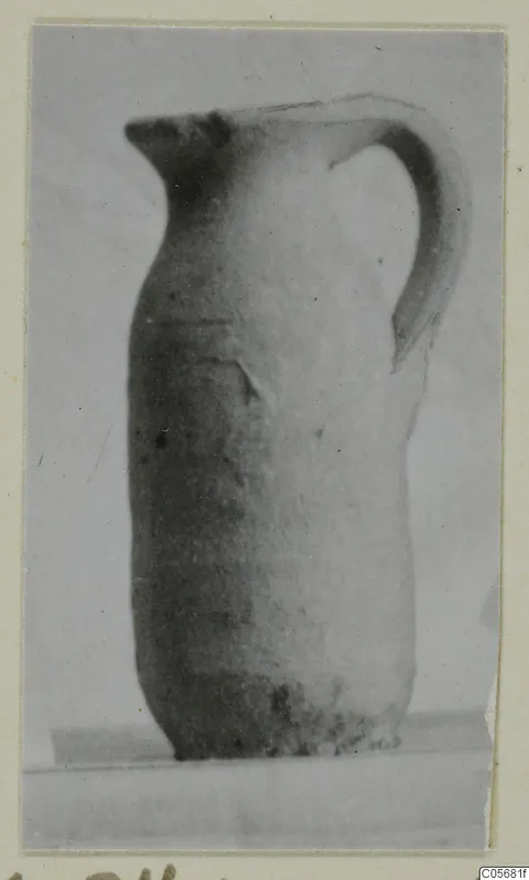 Pottery Plain White VII juglet with a single curved handle, shown in side view