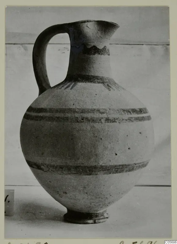 Pottery White Painted I jug with a single handle, a globular body and horizontal painted bands.