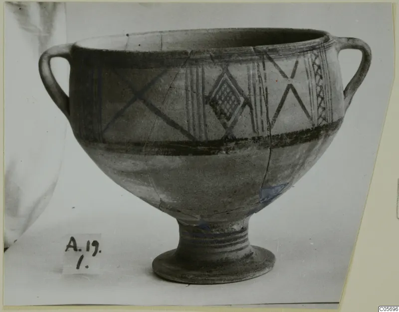 White Painted II bowl with two loop handles and a ring foot, decorated with dark painted bands and crossed lines