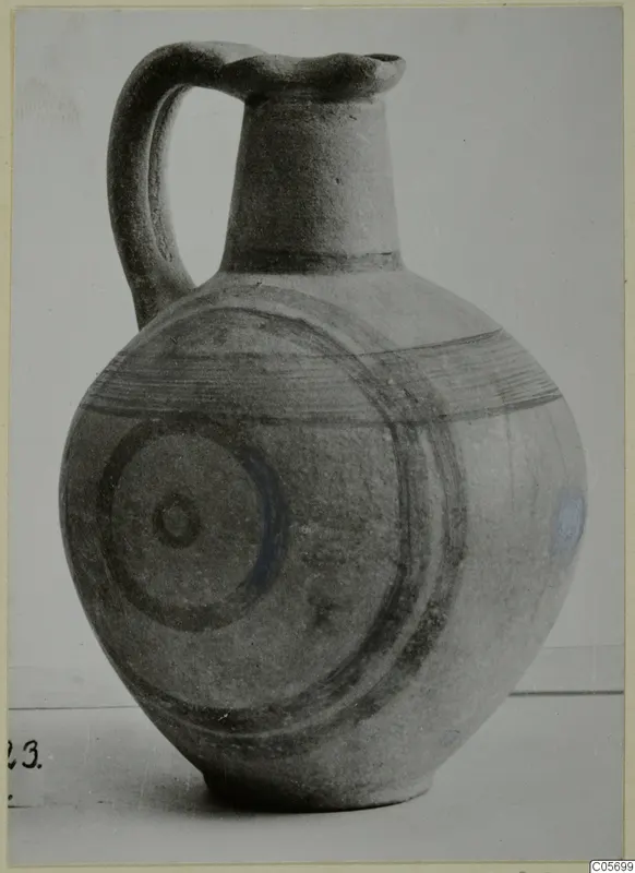 Pottery Black-on-Red II-IV jug with a strap handle, dark painted bands and concentric circles on the body