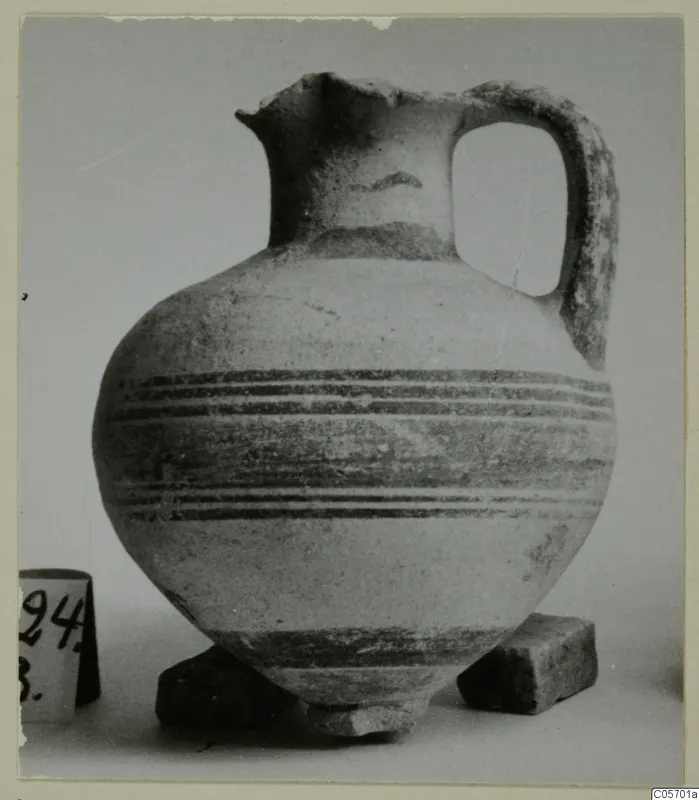 Pottery Bichrome I jug from Amathus with dark horizontal bands and a loop handle, photographed against a plain background