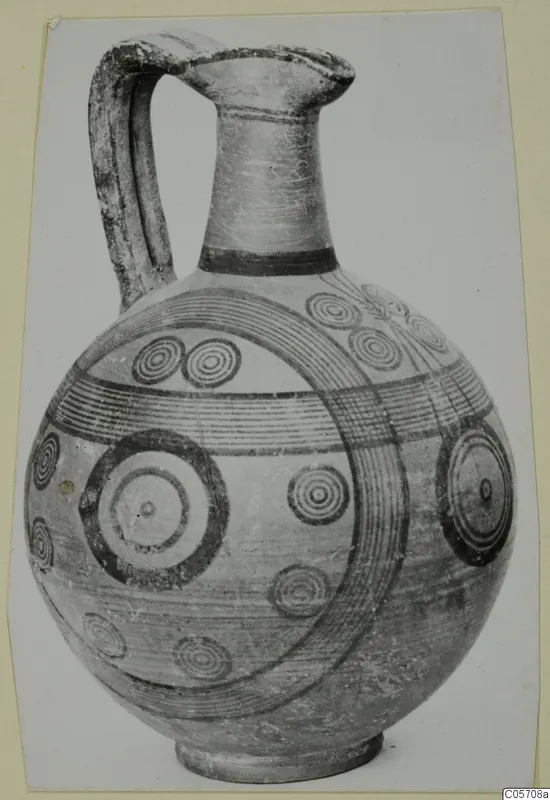 Pottery jug with a tall neck, strap handle and painted concentric circles and bands