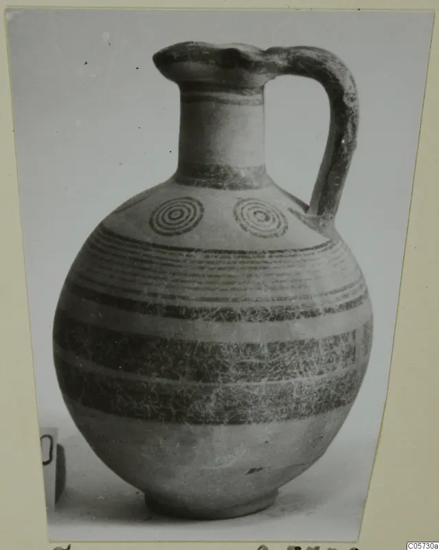 Black-on-Red I-III pottery jug with a strap handle, dark painted bands and concentric circles on the shoulder