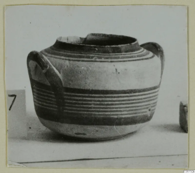 Pottery Bichrome IV jug with two handles and horizontal bands of paint, photographed on a pale surface