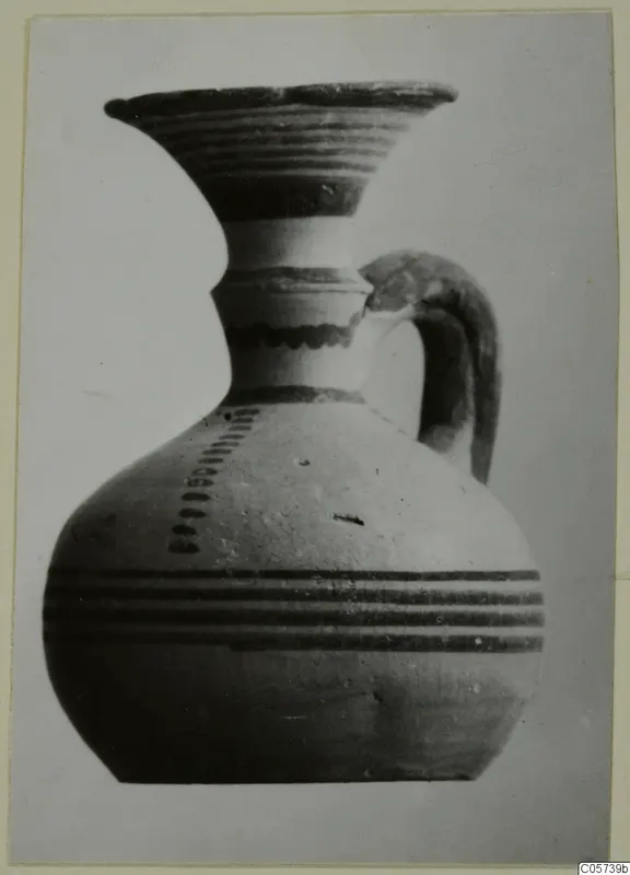 Pottery Black-on-Red I-III: a jug with a flared mouth, dark painted bands and a strap handle, from Amathus tombs 1-9