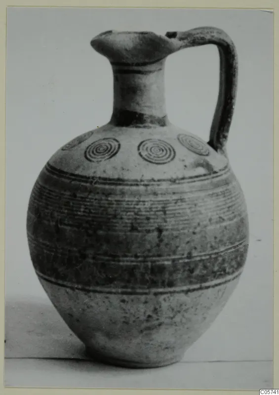 Jug of Pottery Bichrome IV with a banded body and concentric circles on the shoulder, photographed against a plain background