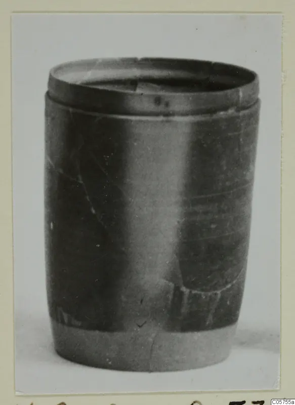 Dark, smooth-surfaced vessel with a raised rim band, photographed upright against a pale background