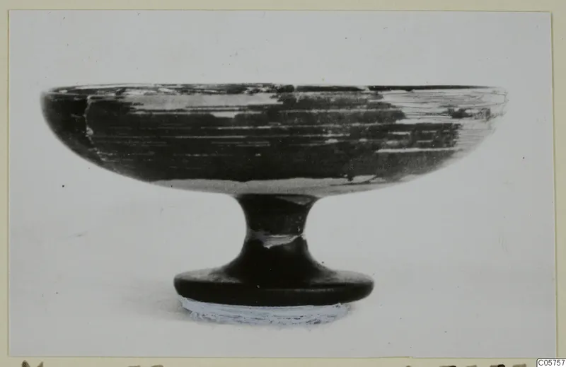 Black-glazed kylix from Marion, tombs 46–60: a shallow footed bowl shown in side view against a plain background