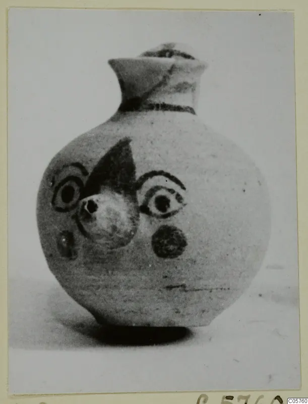 Round jug with a flaring neck and dark painted motifs, including concentric circles and a dark triangle