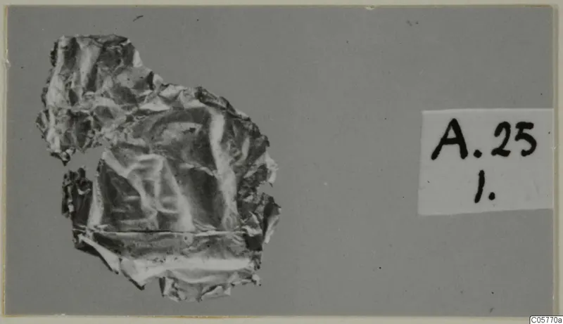 Crumpled metal sheet from Amathus tombs, with a number label beside it.