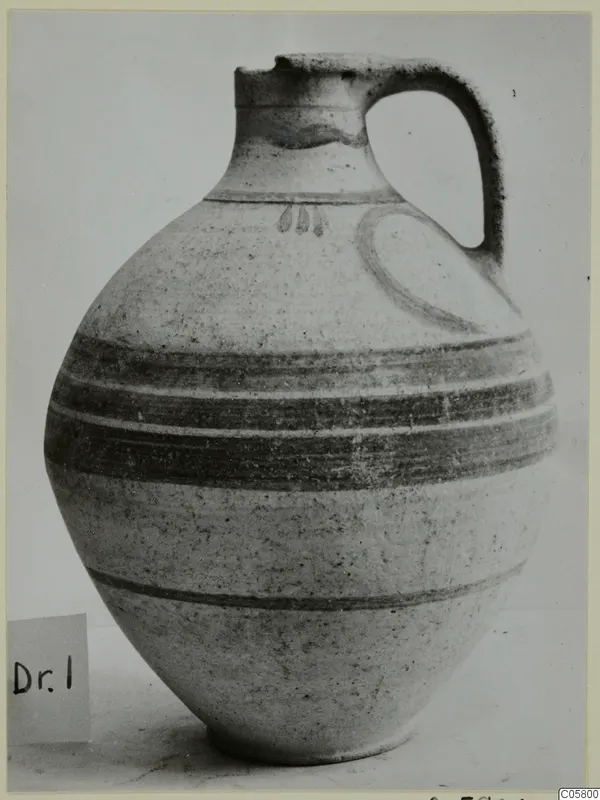 Pottery White Painted VI jug with a single loop handle and dark horizontal bands around the body