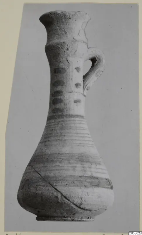 White Painted IV juglet with a single loop handle, a narrow neck and painted horizontal bands.