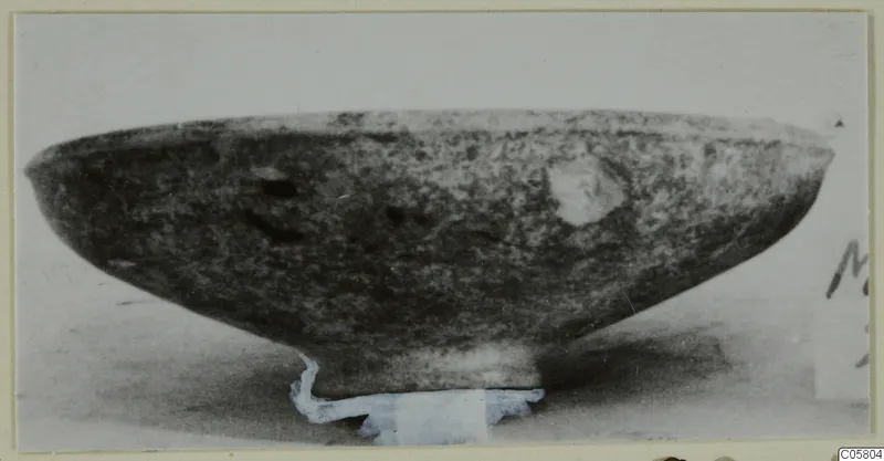 Black Slip bowl with a low foot, shown in side view on a pale support