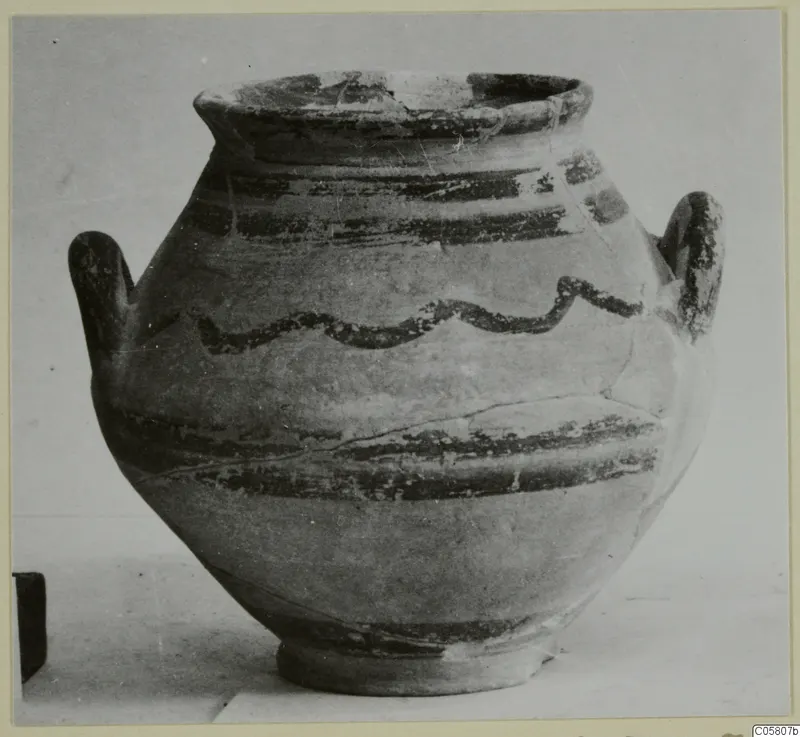 Painted pottery jar with two handles, dark horizontal bands and a wavy line around the shoulder