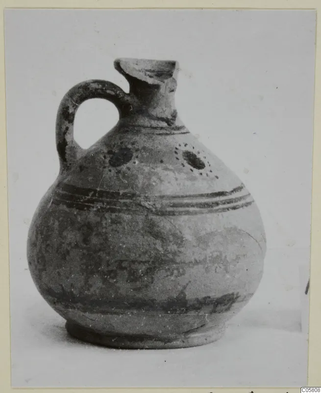 Pottery juglet, White Painted VII, with a loop handle, dark painted bands and dotted circles on the body