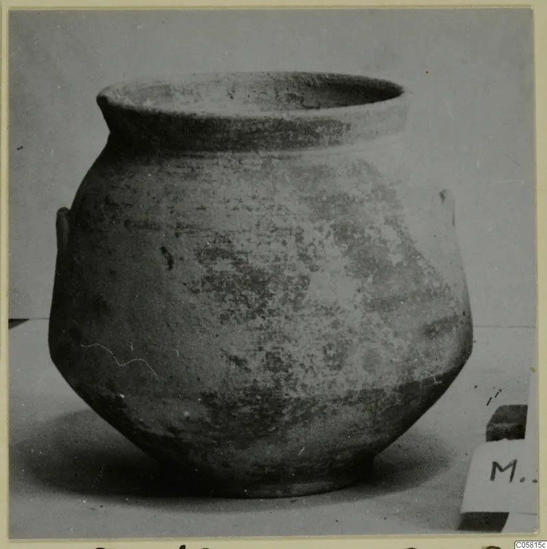 Pottery jar of Bichrome-Red ware with a wide rim and small handles, photographed on a plain surface