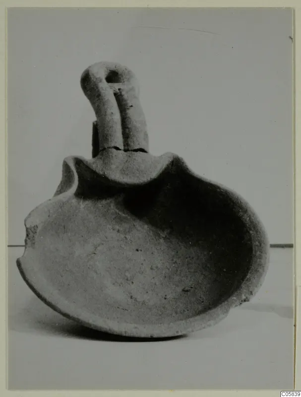 Terracotta lamp with a shallow rounded body, a pinched wavy rim and a loop handle rising from the back