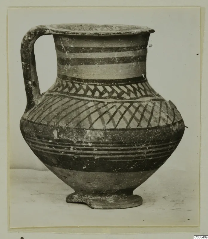 Pottery Bichrome V jug with a single handle, painted with dark bands and hatched patterns