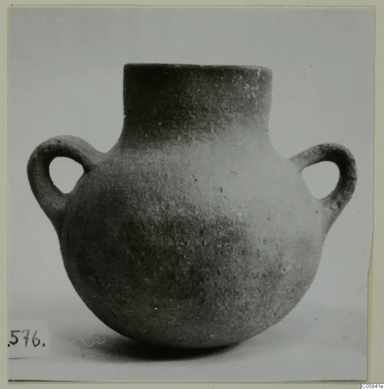 Round two-handled pottery jar with a short neck, photographed against a plain grey background.
