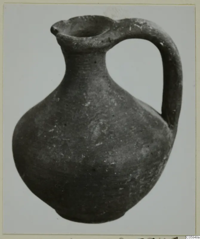 Juglet from Marion with a single loop handle and a pinched, lipped mouth.