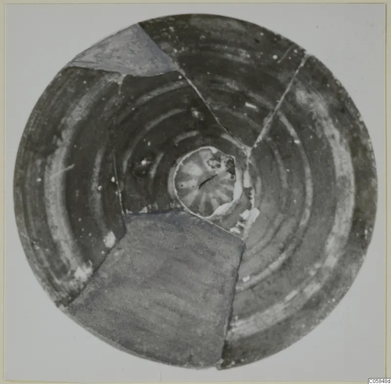 Pottery lid from Amathus, seen from above, with concentric pale bands around a central knob, mended from fragments