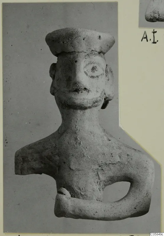 Terracotta figurine of a head and upper body with a flat cap, photographed on a grey card mount