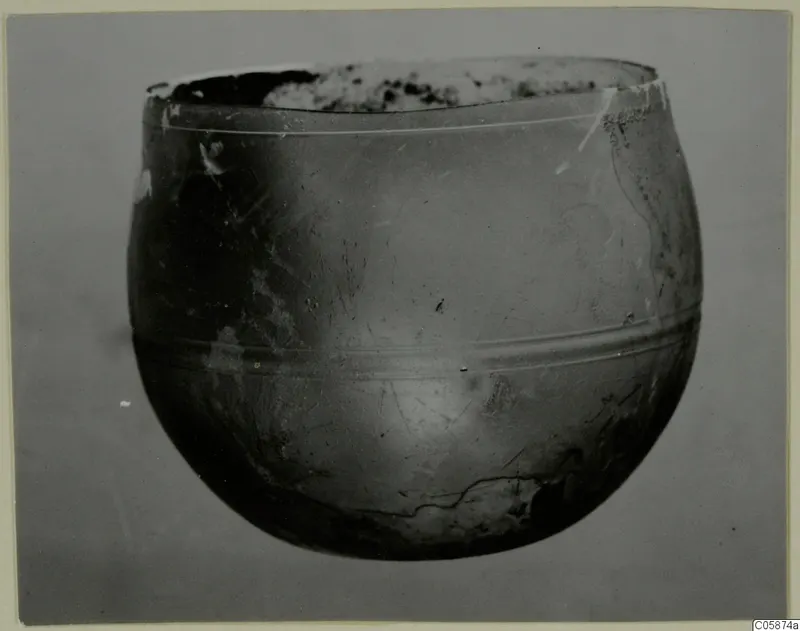 Rounded glass vessel from Idalion with a wide, broken mouth and two horizontal bands around its body