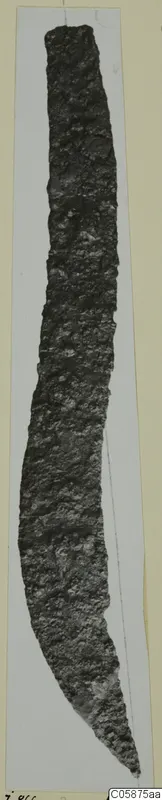 Long, narrow iron knife blade, heavily corroded, curving and tapering to a point