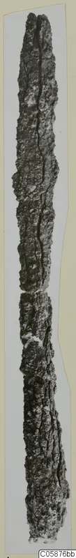 Long corroded iron weapon, shown upright against a pale background